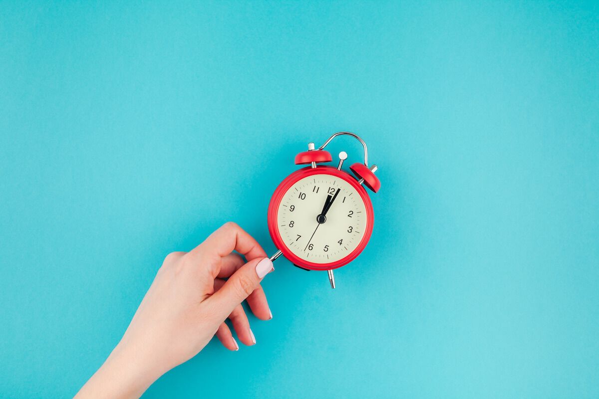 Person holding an alarm clock