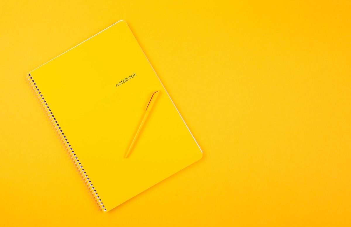 Personal knowledge management: yellow notebook and a yellow pen
