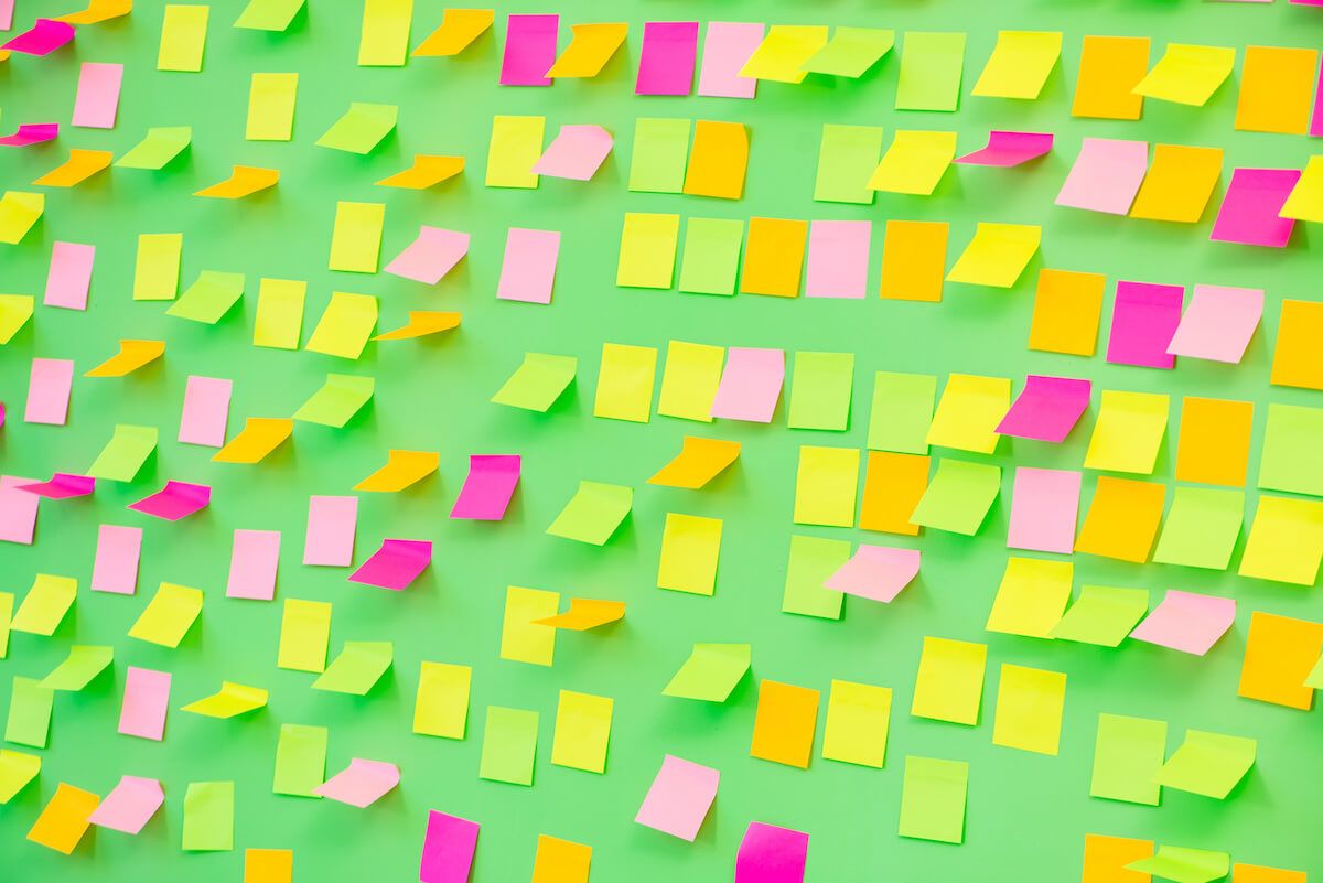 Too many tabs open: sticky notes on a green wall