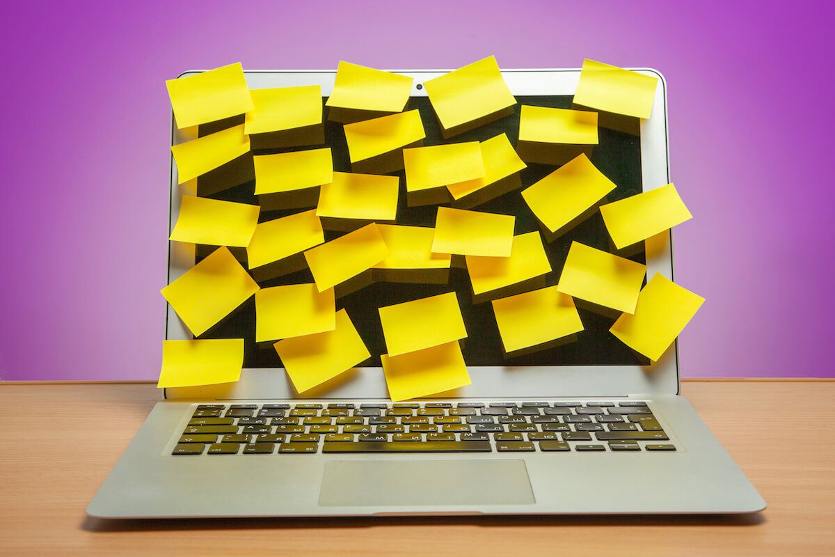 Too many tabs open: yellow sticky notes on a laptop screen