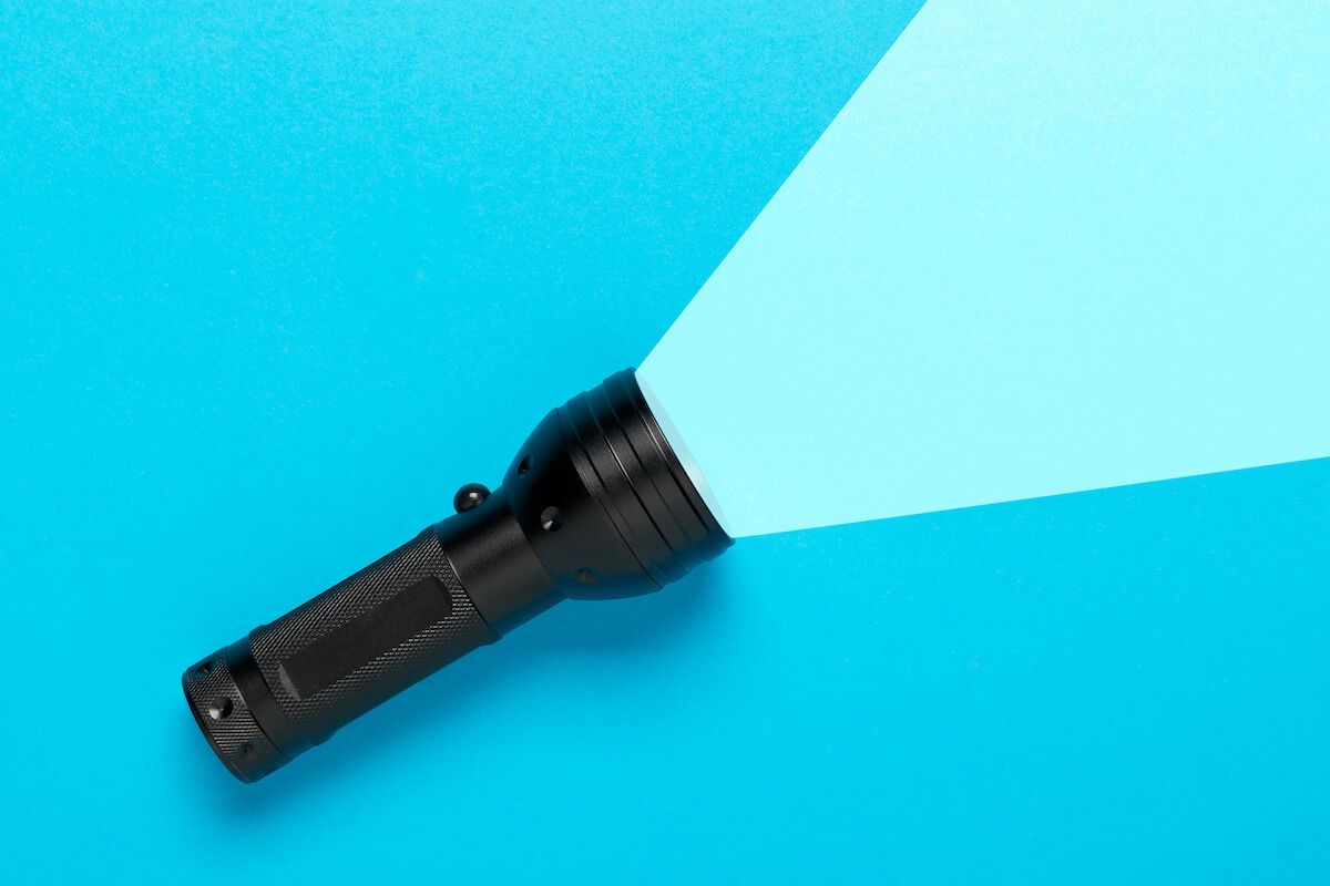 Black flashlight on a blue background